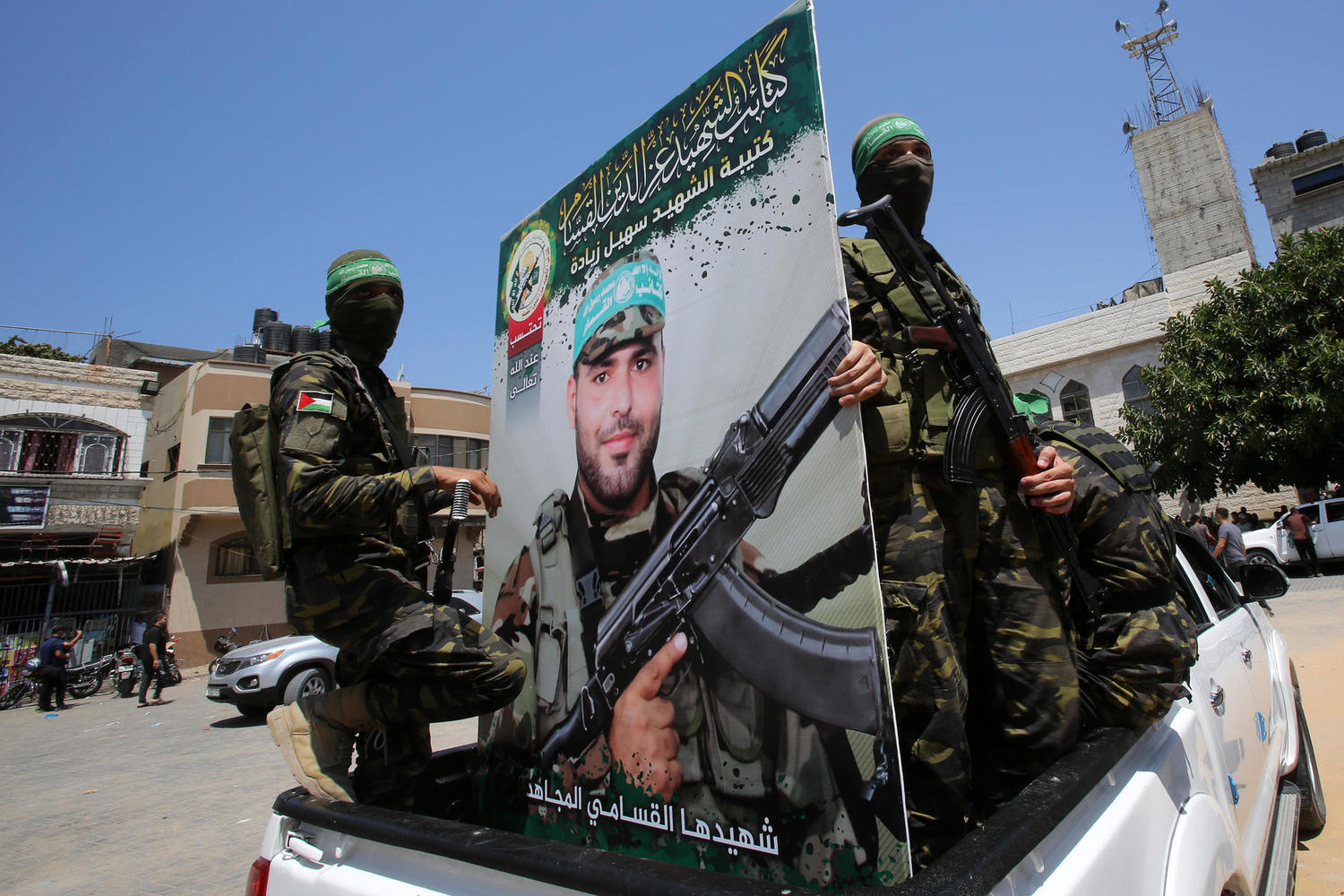боевики «Бригад Изеддина аль-Кассама» с портретом «мученика»